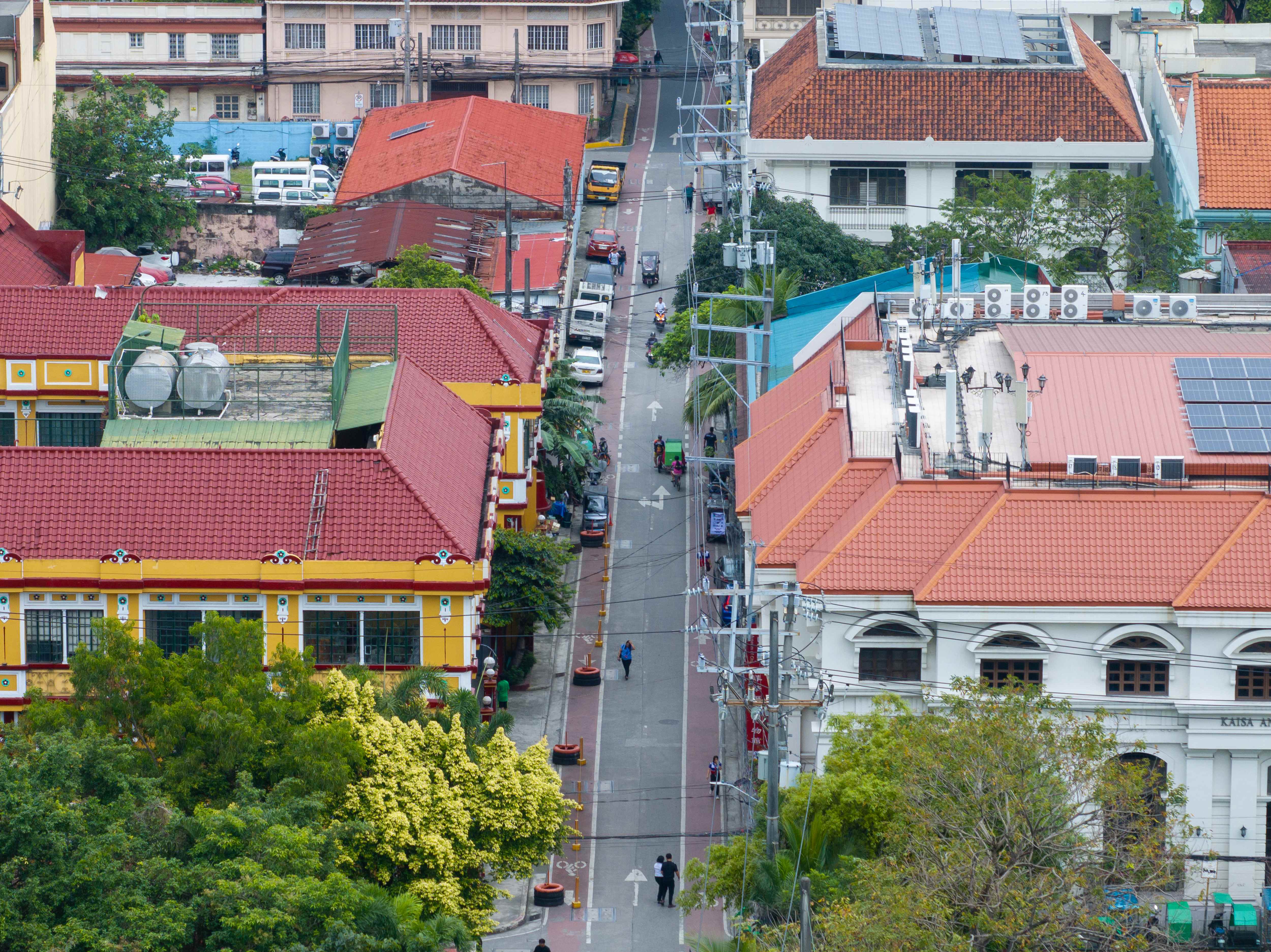 A dense city street on a hot day with pedestrians and traffic